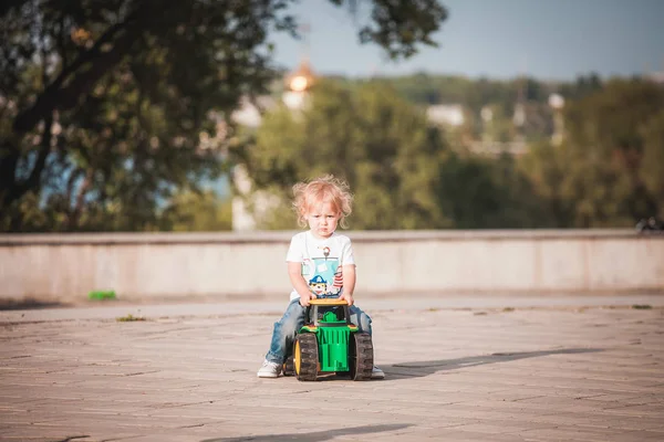 Милый мальчик играет с игрушечным трактором — стоковое фото