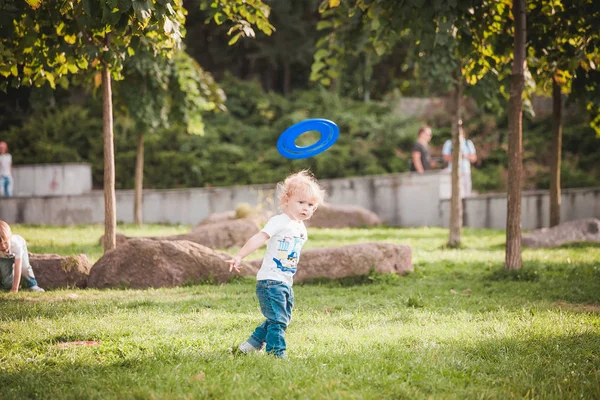 Familia jugando frisbee en el prado en el parque — Foto de Stock