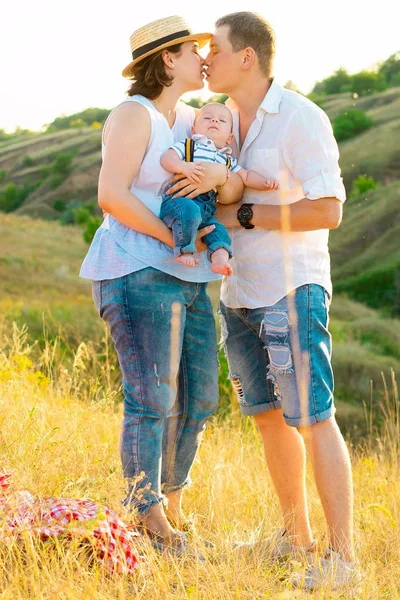Happy family with little baby spending time together at sunset — Stock Photo, Image
