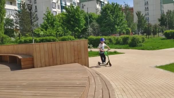 Kind een scooter rijden — Stockvideo