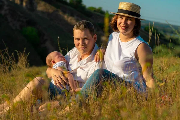 Família com bebê no pôr do sol de verão. — Fotografia de Stock