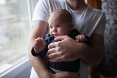 Babası küçük bebeğini kucağında tutuyor.
