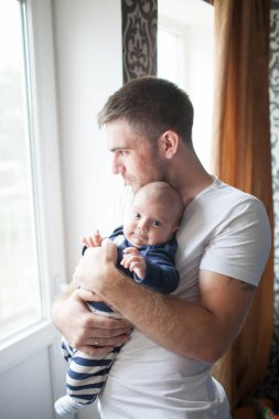 Babası küçük bebeğini kucağında tutuyor.