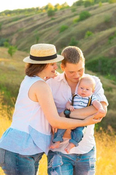 Gezin met baby bij zonsondergang. — Stockfoto