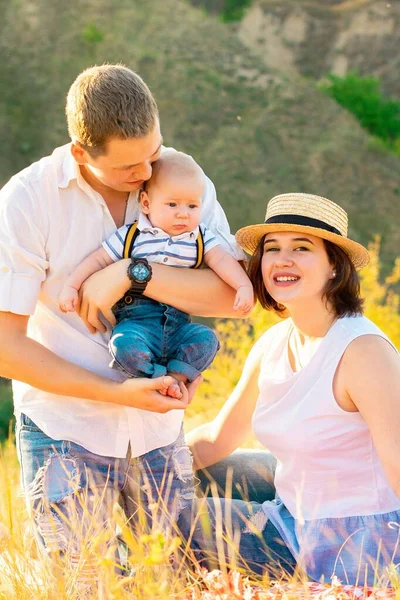 Família com bebê no pôr do sol de verão. — Fotografia de Stock