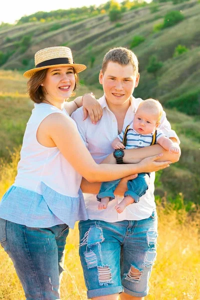 Familj med barn vid sommarsolnedgången. — Stockfoto