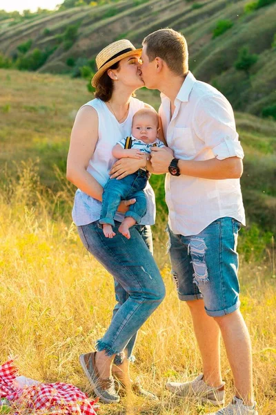 Família feliz com pouco bebê passar o tempo juntos ao pôr do sol — Fotografia de Stock