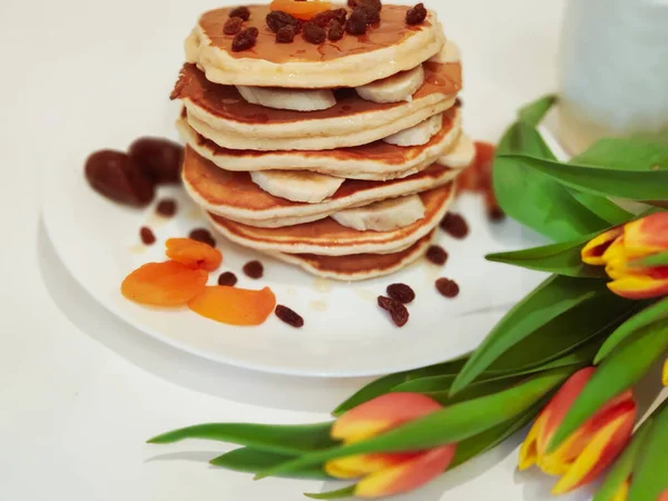 Stack pannkakor på bordet med tulpaner Royaltyfria Stockbilder