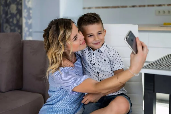 Мать с сыном делают селфи на смартфоне — стоковое фото