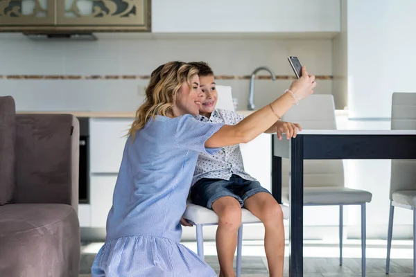 Мать с сыном делают селфи на смартфоне — стоковое фото