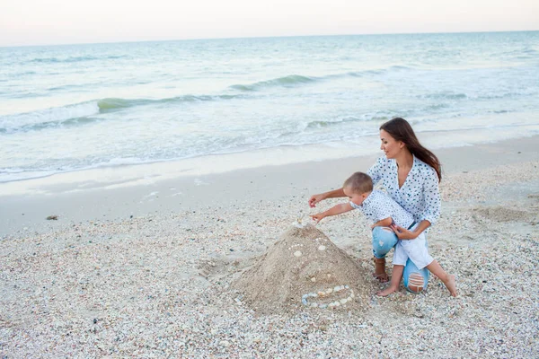 Мать и сын играют у моря на берегу моря — стоковое фото