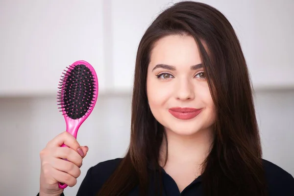Girl holds a hairbrush — Stock Photo, Image