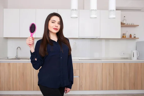 Girl holds a hairbrush without hair and smiling — Stock Photo, Image