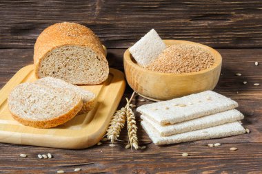 Buğday kepeği, kepekli ekmek ve ahşap bir masa üzerinde kuru bisküvi