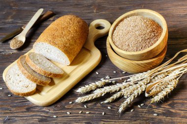 Buğday kepeği ve un ekmek ile kepek ahşap bir masa üzerinde ahşap tablo