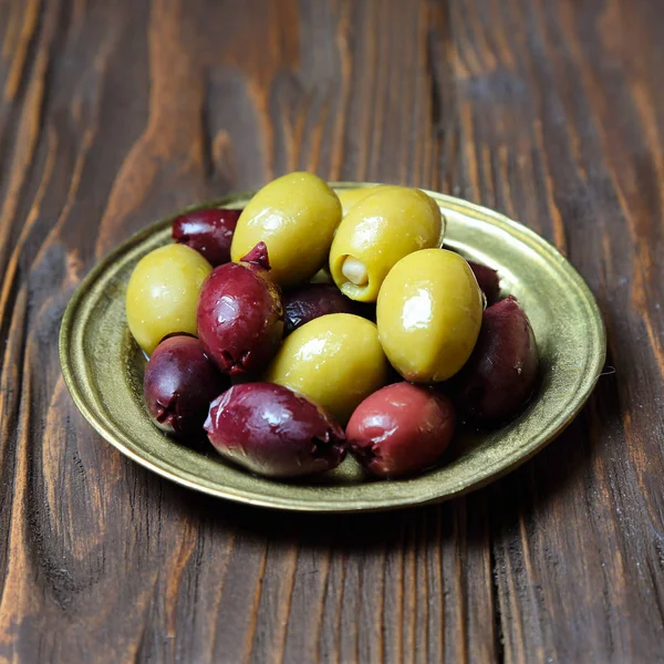 Olive in una piastra di bronzo sul tavolo della cucina — Foto Stock