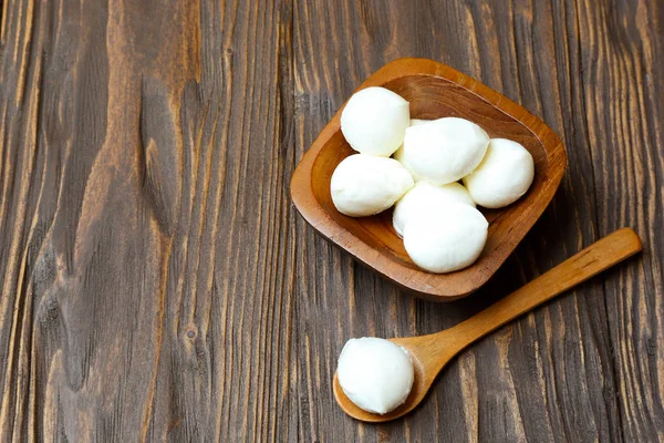 Queso mozzarella en un tazón de madera sobre la mesa — Foto de Stock