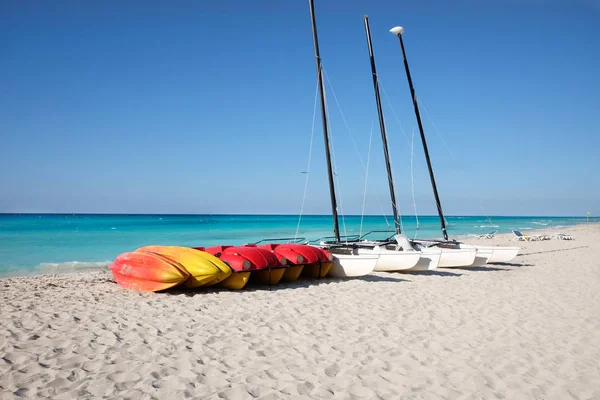 Canoes and catamarans on a sandy beach against the blue sea — Stock Photo, Image