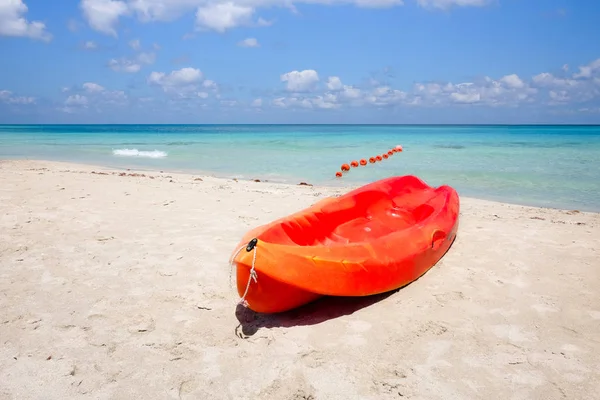 Orange canoe on a sandy beach against the sea — Stock Photo, Image