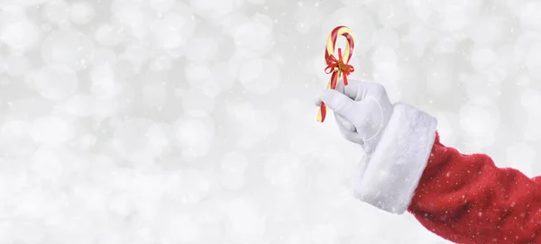 Santa Claus Hand Holding Candy Cane Silver Bokeh Background Snow — Stock Photo, Image