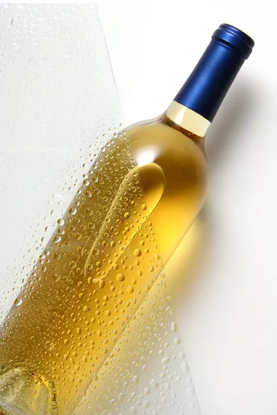 Uma garrafa de vinho branco atrás de uma folha de vidro com gotas de água — Fotografia de Stock