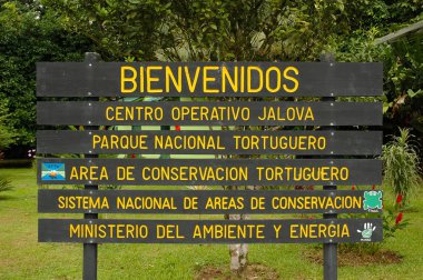 TORTUGUERO, COSTA RICA - JULY 15, 2005: Sign at the entrance to Tortuguero National Park on the east coast of Central America. clipart