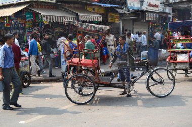 Yeni Delhi, Hindistan - 27 Ekim 2015: Kalabalık sokak sahne Yeni Delhi taksici ile. Pedicabs Asya'nın birçok kişi için gelir kaynağı vardır.