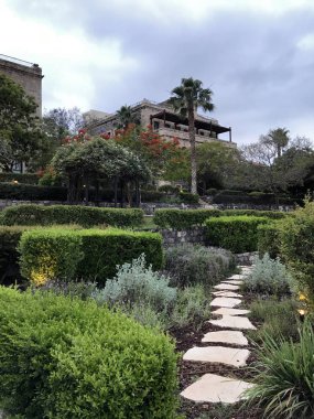 TIBERIAS, ISRAEL - MAY 14, 2018: Scots Hotel garden path overlooking the Sea of Galilee. The hotel was once the site of a 19th-century Scottish hospital. clipart
