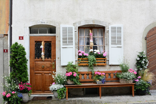 GRUYERES, SWITZERLAND - JULY 8, 2014: Front door on traditional Swiss home. The picturesque home is on the cobblestone main street in old town Gruyeres leading to the castle and church.