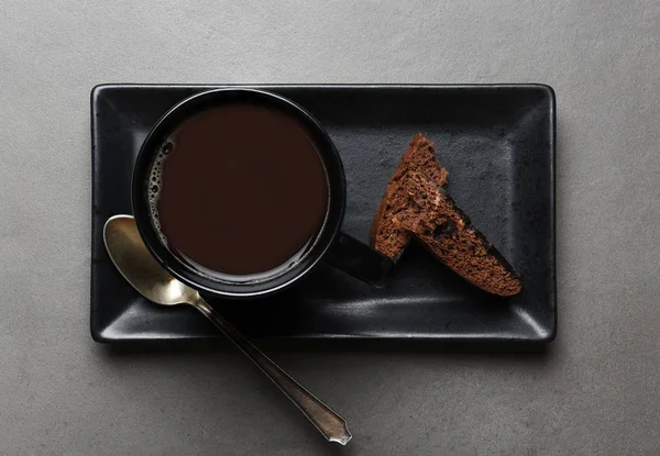 在石板灰色桌子上的长方形盘子上看到一杯咖啡和巧克力比斯科蒂 — 图库照片