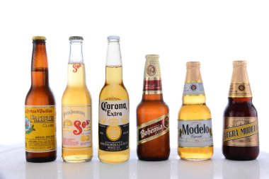 IRVINE, CA - JUNE 14, 2015: Popular Mexican Beers. Pacifico, Sol, Corona, Bohemia and Modelo beer bottles on a wet table with reflections.  clipart