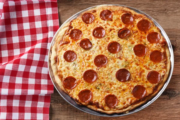 Fresh Homemade Pepproni Pizza on a red checkered table cloth — Stock Photo, Image