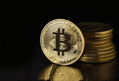 Bitcoin: Kenar ayakta önünde siyah yansıma ve kopya alanı olan bir yığın üzerinde dijital para veya Cryptocurrency, fiziksel bit sikke de denir.