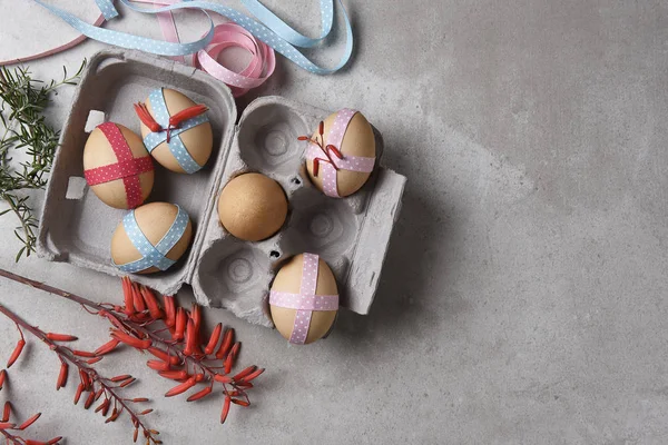 Nastro decorato uova marroni in una scatola su superficie piastrellata grigia arguzia — Foto Stock