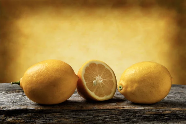 Closeup Three Lemons One Cut Rustic Wood Table Warm Mottled — Stock Photo, Image