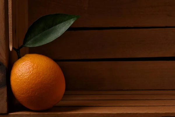 Closeup de un naranja fresco recogido en un cajón de embalaje de madera. —  Fotos de Stock