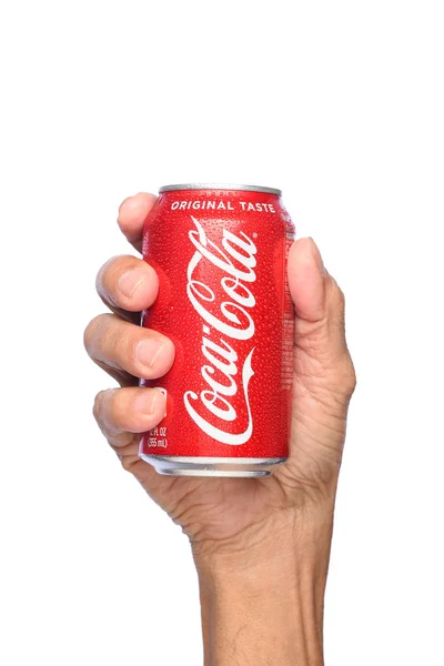 Fechar de uma mão segurando uma lata fria de Coca-Cola . — Fotografia de Stock