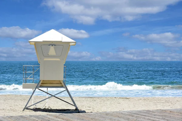 Badmeester staan op een strand met de Oceaan en golven en bewolkte s — Stockfoto