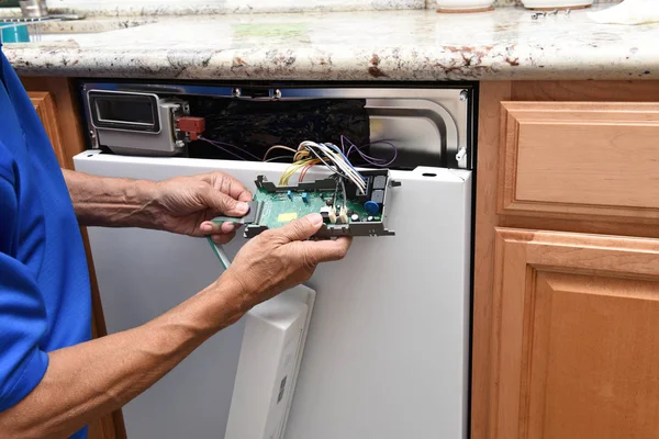 Primer plano de un reparador de electrodomésticos desenchufando el panel de control a — Foto de Stock