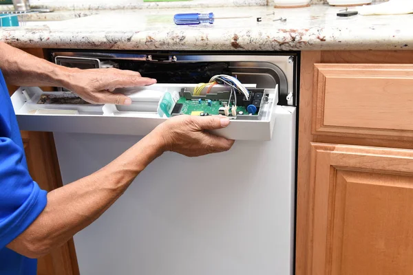 Primer plano de un reparador de electrodomésticos que retira el panel de control a un — Foto de Stock