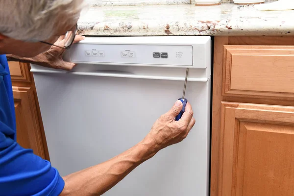 Primer plano de un reparador de electrodomésticos utilizando un destornillador para eliminar t — Foto de Stock