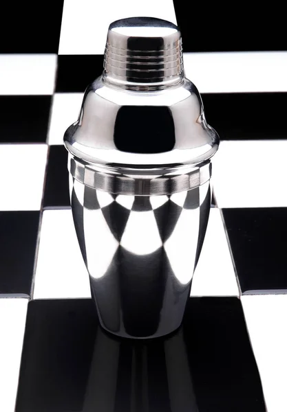Nahaufnahme eines Martini-Shakers auf einem schwarz-weißen Schachbrett — Stockfoto