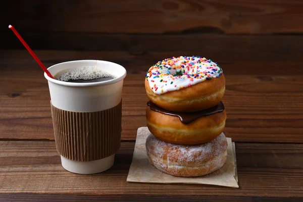 Una tazza di carta di caffè caldo appena fatto accanto a una pila di fantasia — Foto Stock