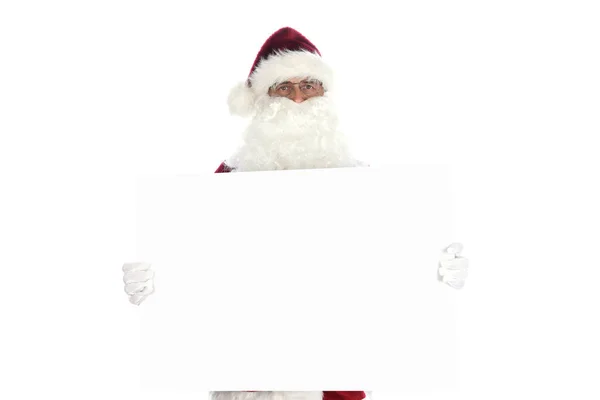老男人穿着传统的圣诞老人服装 拿着空白的白色标志准备给你复印 与白种人隔离 — 图库照片