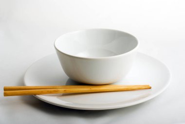 beyaz porselen tabak ve kase seti üzerinde chop-sticks