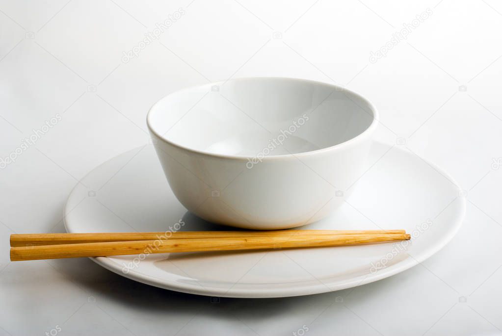 chop-sticks on set of white porcelain plate & bowl