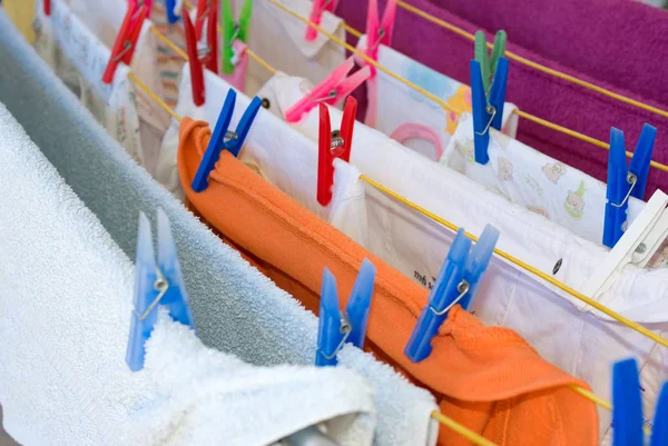 Hanging clothes and colorfull plastic cloth pegs — Stock Photo, Image