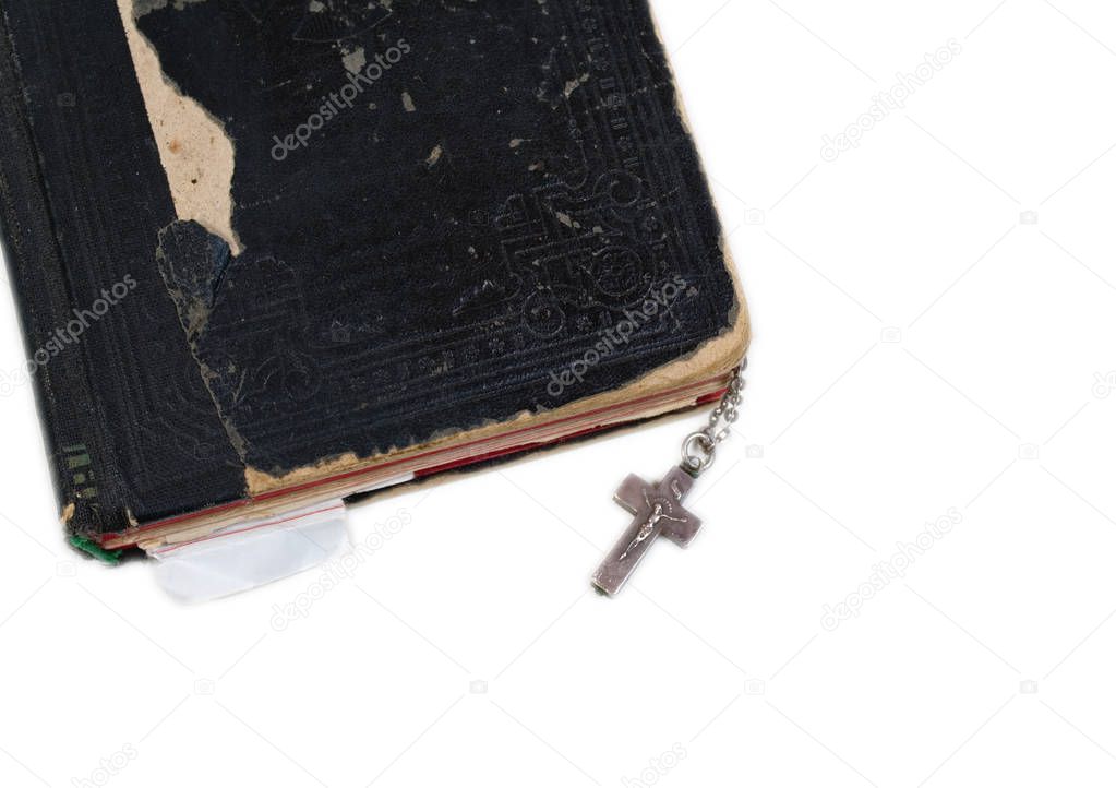silver cross on old bible with leather cover