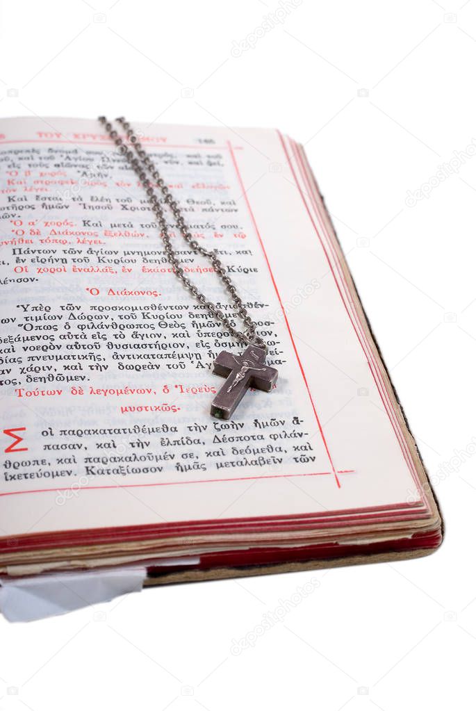 silver cross in an open old bible with leather cover