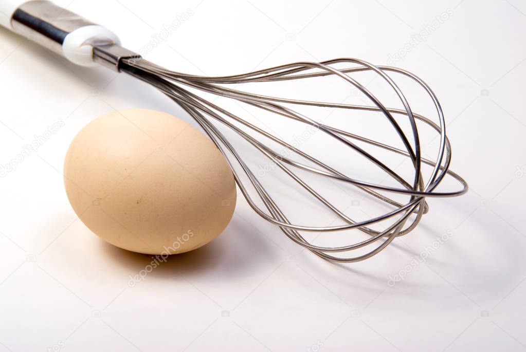 egg and whisk on white background